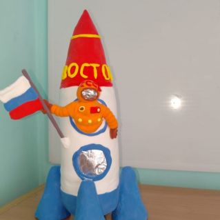 В космической ракете с названием "Восток". Он первый на планете. Подняться к звездам смог!